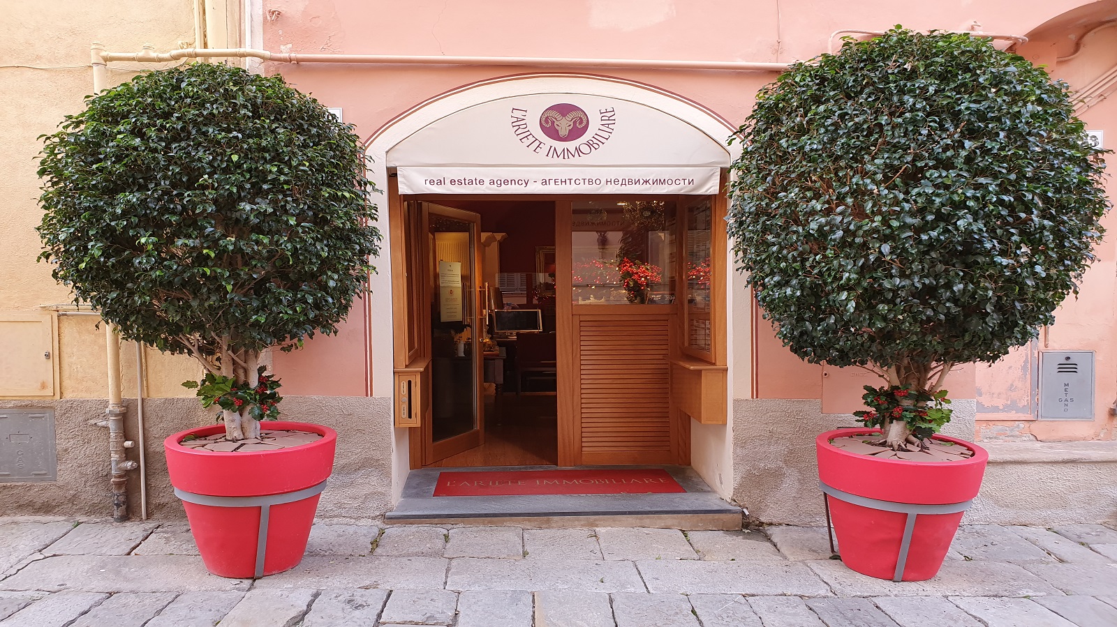 L'entrata dell'agenzia immobiliare identificata da due grandi vasi rossi